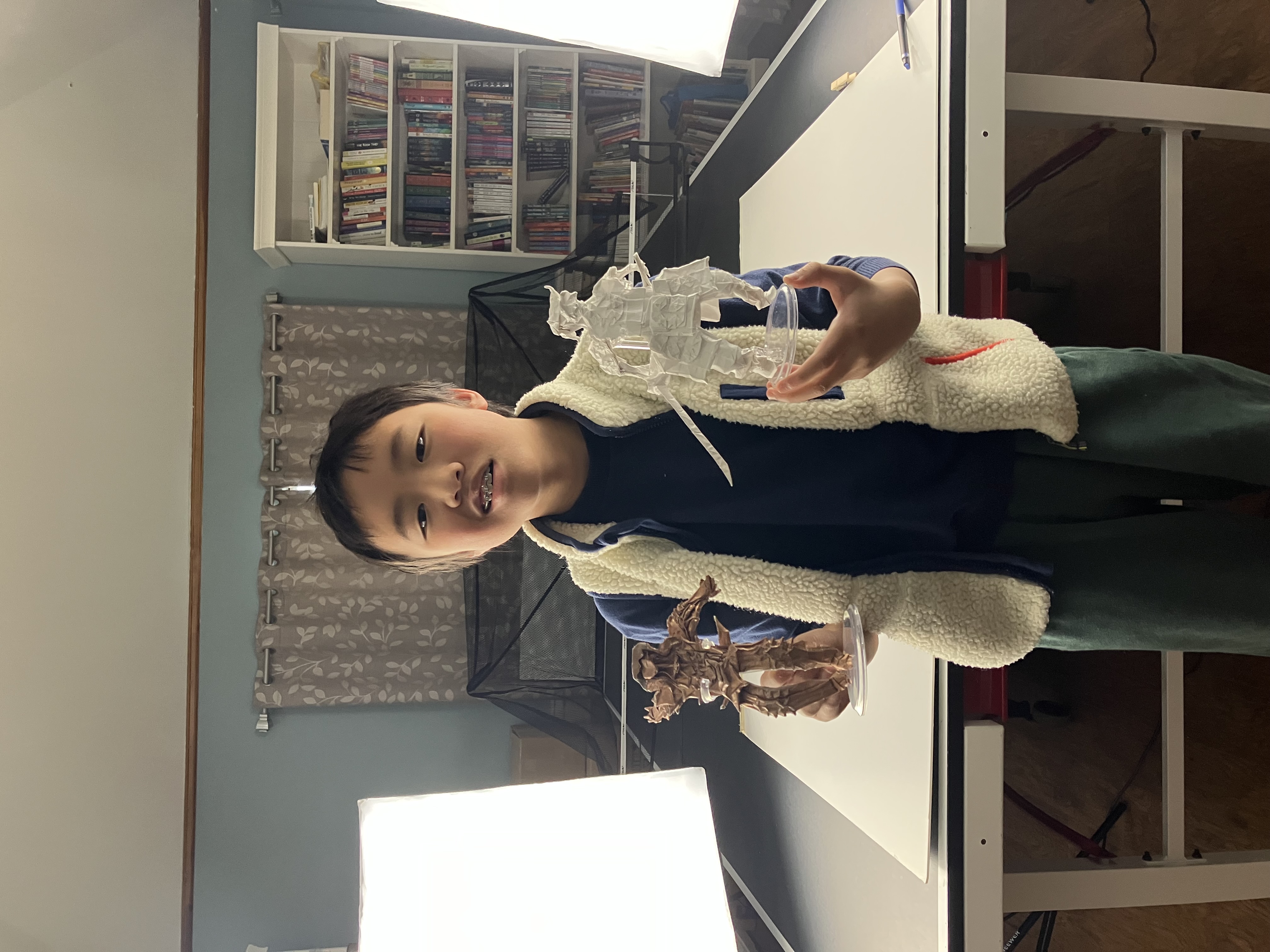 Artist holding two origami warriors